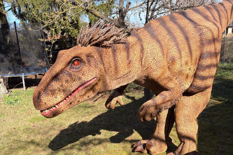 Ein großer Dinosaurier mit gestreifter Haut und leuchtend roten Augen in einem Garten.
